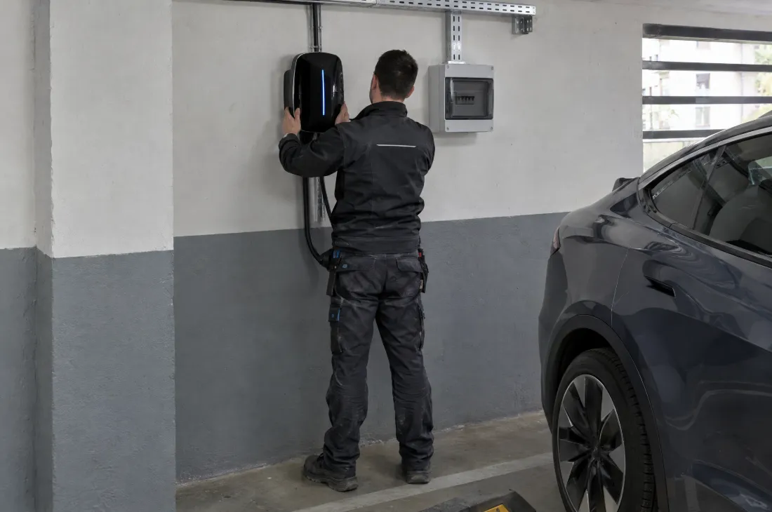 Električar ugrađuje zidni punjač u garaži stambene zgrade