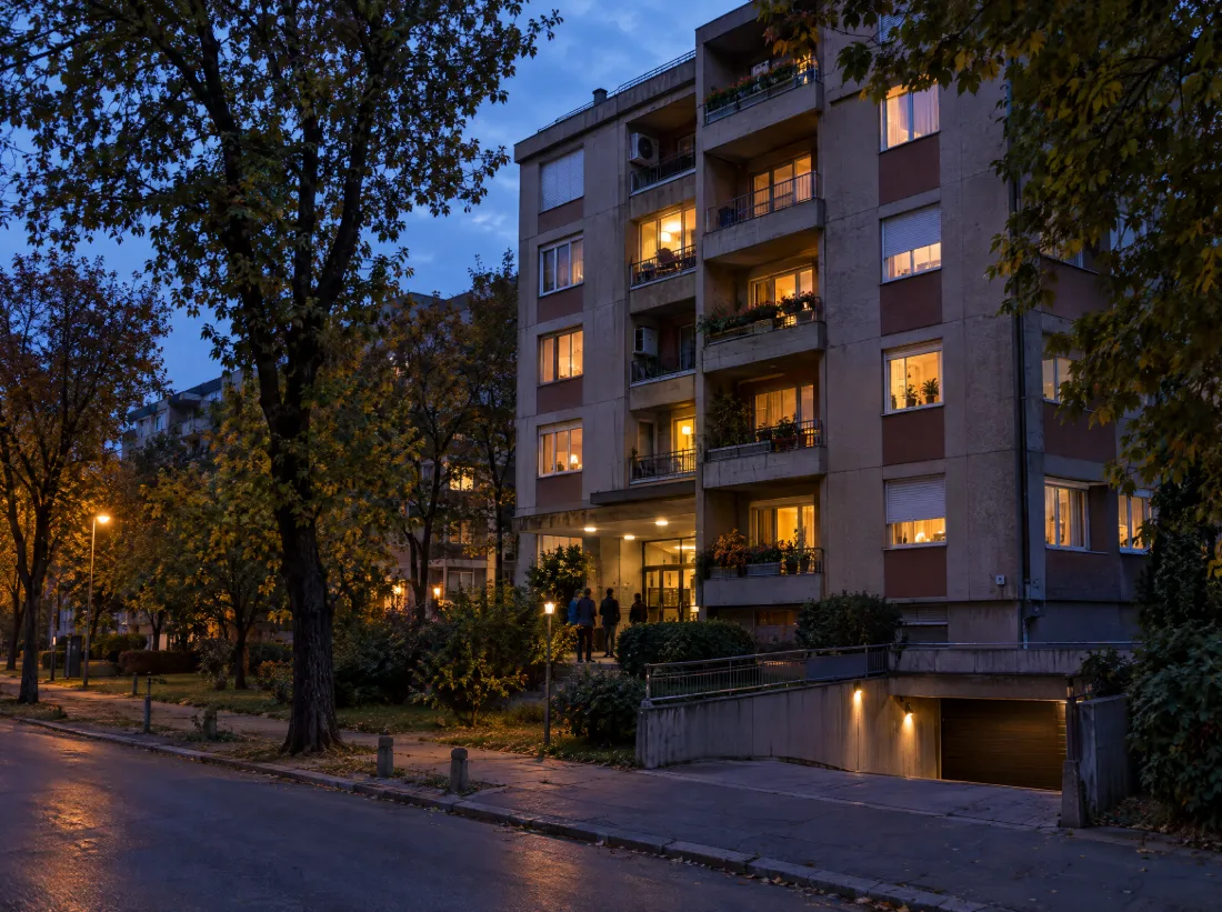 Stambena zgrada u Novom Sadu u sumrak, sa ulazom u garažu